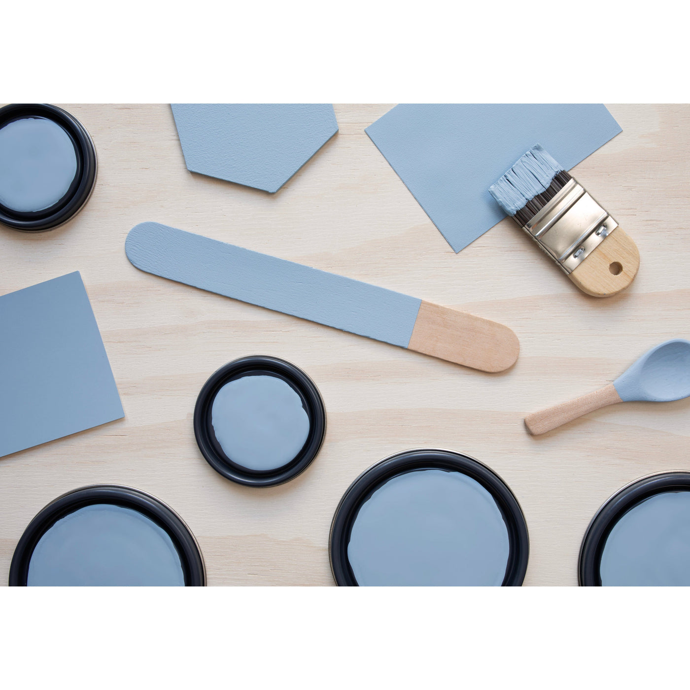 flatlay with wood hexagons, small paint brush, paint lids and wooden spoons all painted in Country Air