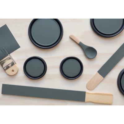 flatlay with paint lids, small paint brush, wooden spoon, rounded sticks  and  stir stick painted in Aegean Sea