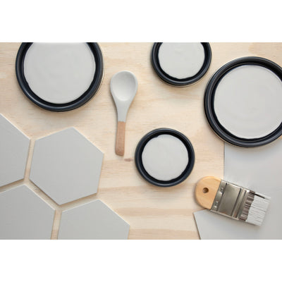 flatlay with wood hexagons, small paint brush, paint lids and wooden spoons all painted in Cloud