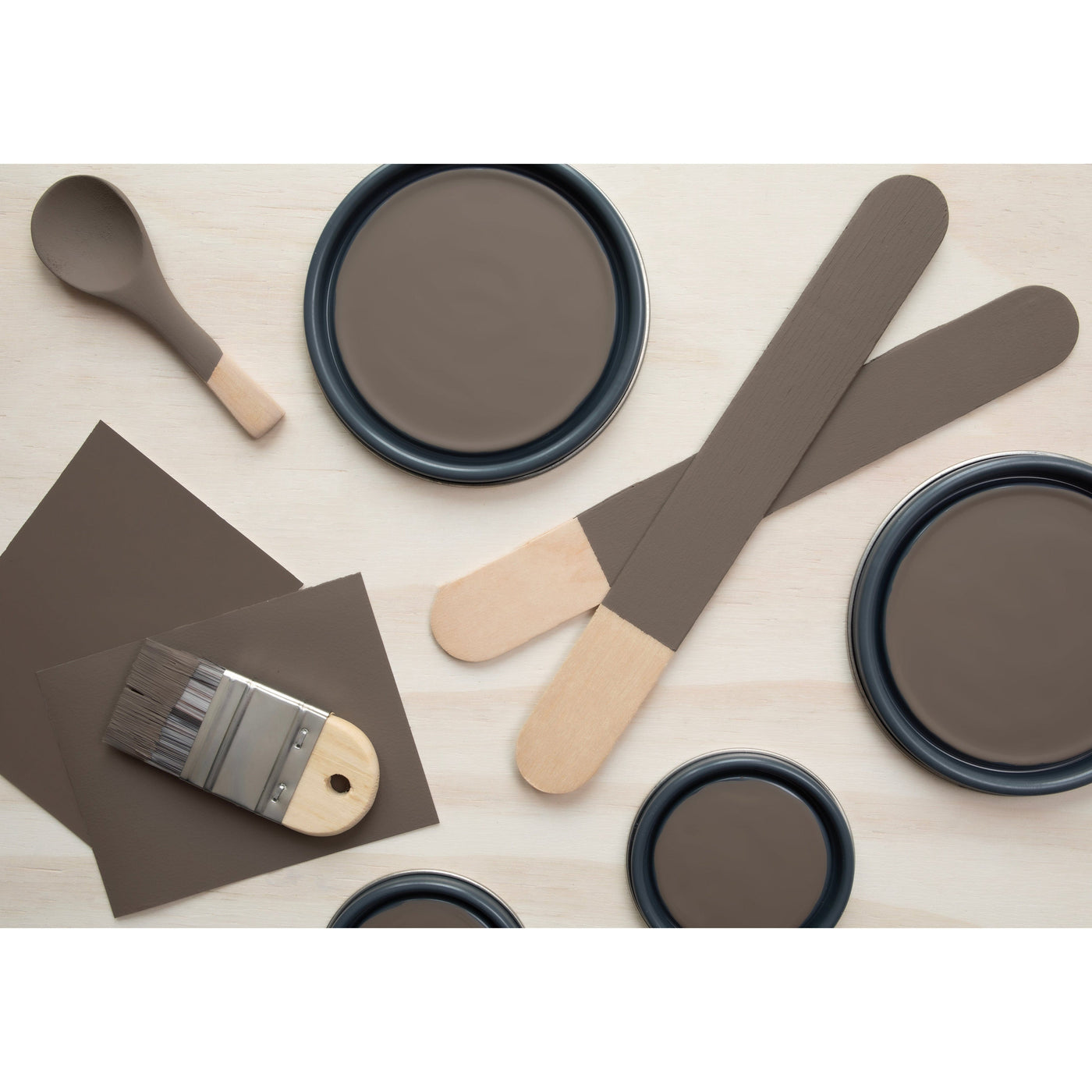 flatlay with paint lids, small paint brush, wooded spoons and rounded sticks painted in Cocoa Powder