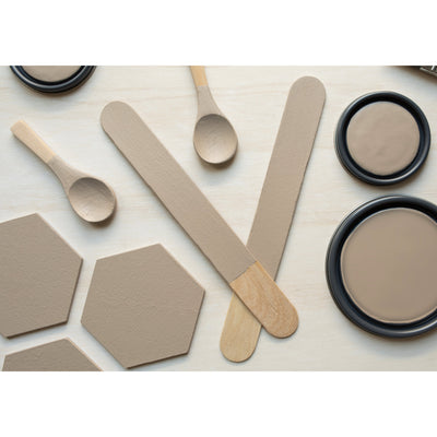 flatlay with wood hexagons, small paint brush, paint lids and wooden spoons all painted in  Hickory