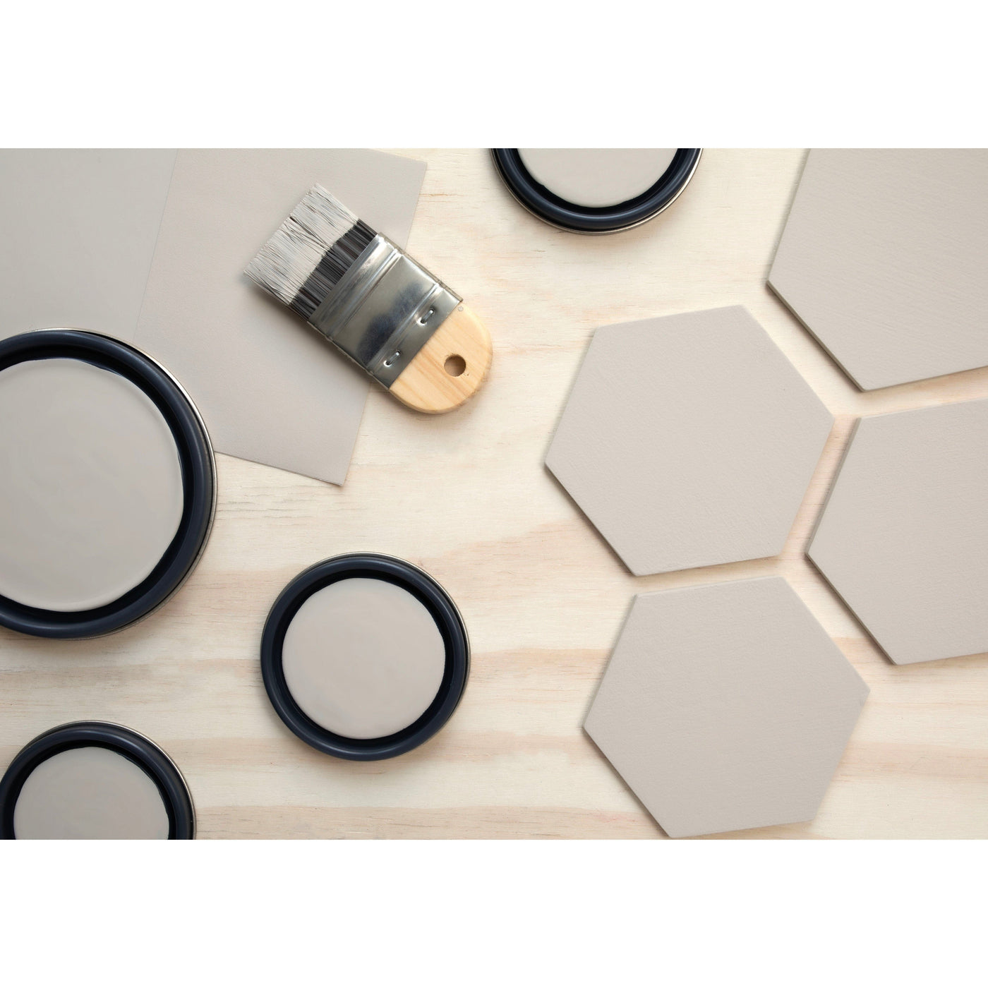 flatlay with wood hexagons, small paint brush, paint lids and wooden spoons all painted in Fine Grain