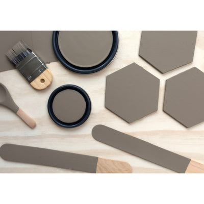 flatlay with wood hexagons, small paint brush, paint lids and wooden spoons all painted in Bison Beige