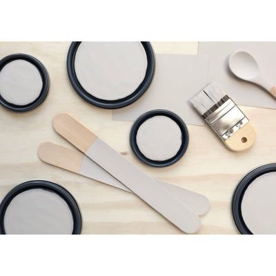 flatlay with paint lids, small paint brush, wooden spoons and rounded sticks painted in En Plein Air