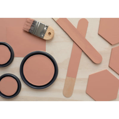 flatlay with wood hexagons, small paint brush, paint lids and wooden spoons all painted in Cedarville