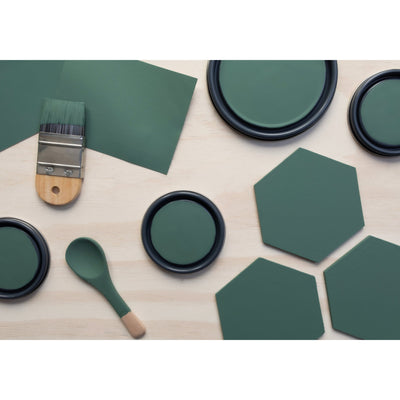 flatlay with wood hexagons, small paint brush, paint lids and wooden spoons all painted in Ecological