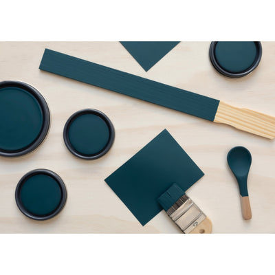 flatlay with paint lids, small paint brush, wooden spoons and stir stick painted in Aegean Sea