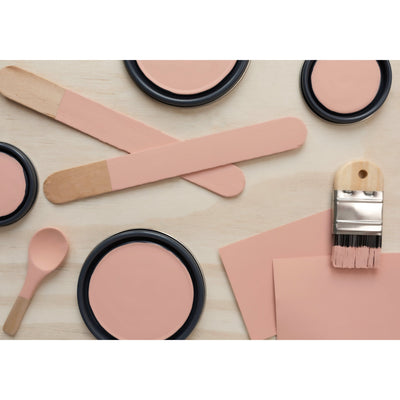 flatlay photo showing color variation from digital, color chip and paintedflatlay with paint lids, small paint brush, wooded spoons and rounded sticks painted in City of Pink Angels