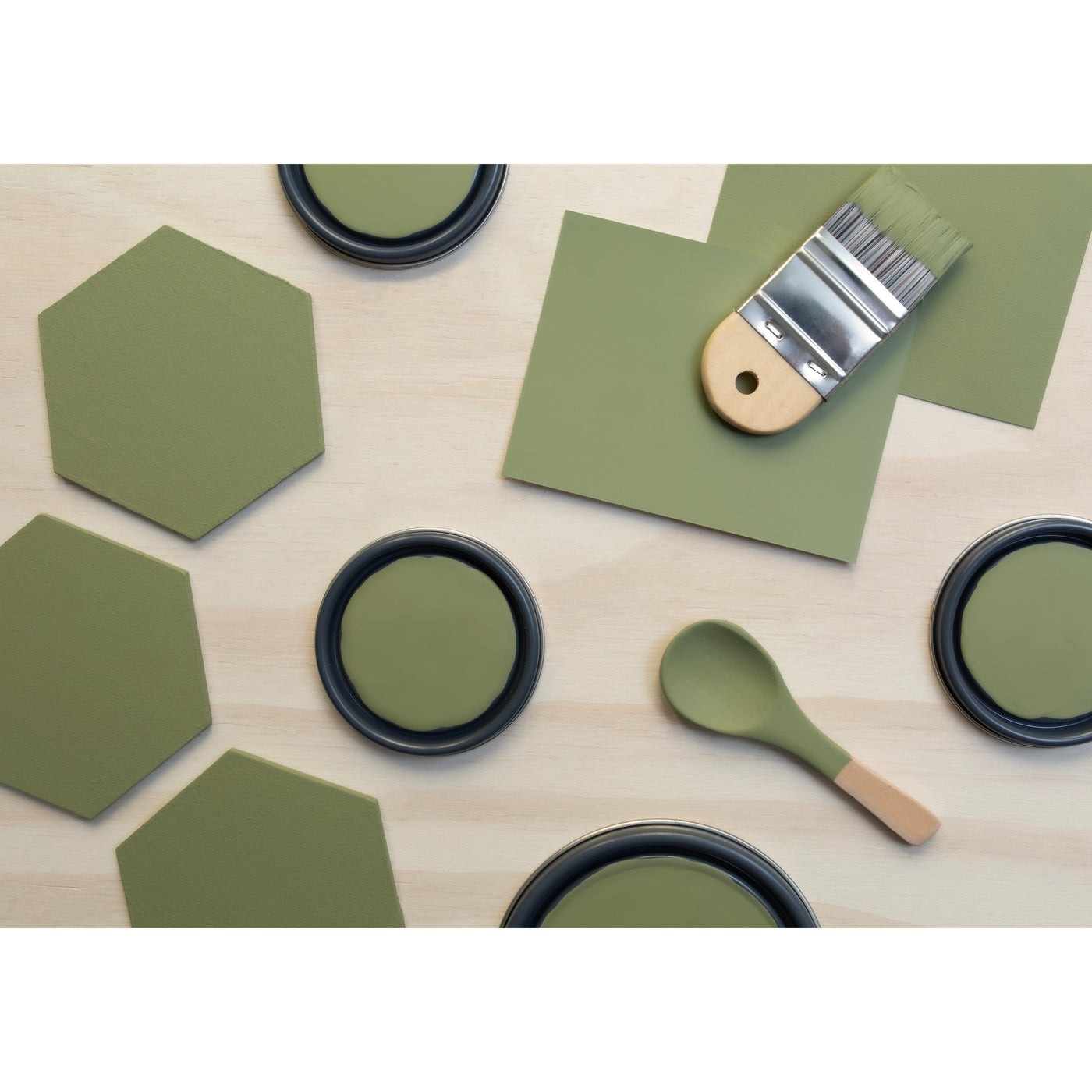 flatlay with wood hexagons, small paint brush, paint lids and wooden spoons all painted in Desert Sage