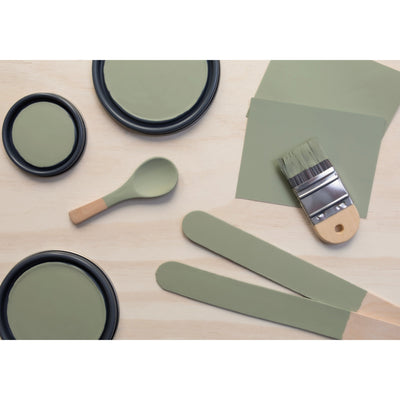 flatlay with paint lids, small paint brush, wooden spoons and rounded sticks painted in Flagstone Quartzite